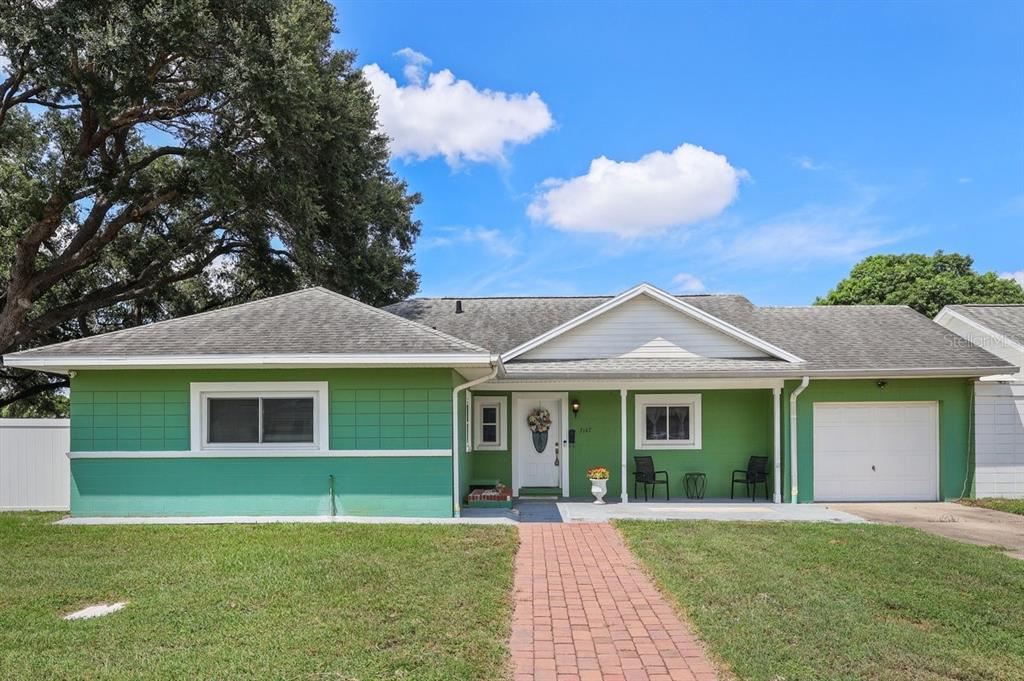 A single-story green house with a brick walkway, a front porch, and a garage — 3147 ANDROS PLACE, ORLANDO, FL