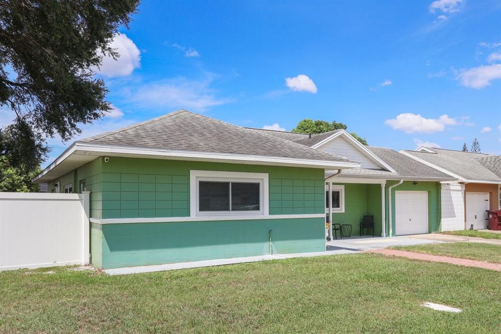A green single-story house with a white trim, a garage, and a white privacy fence — 3147 ANDROS PLACE, ORLANDO, FL