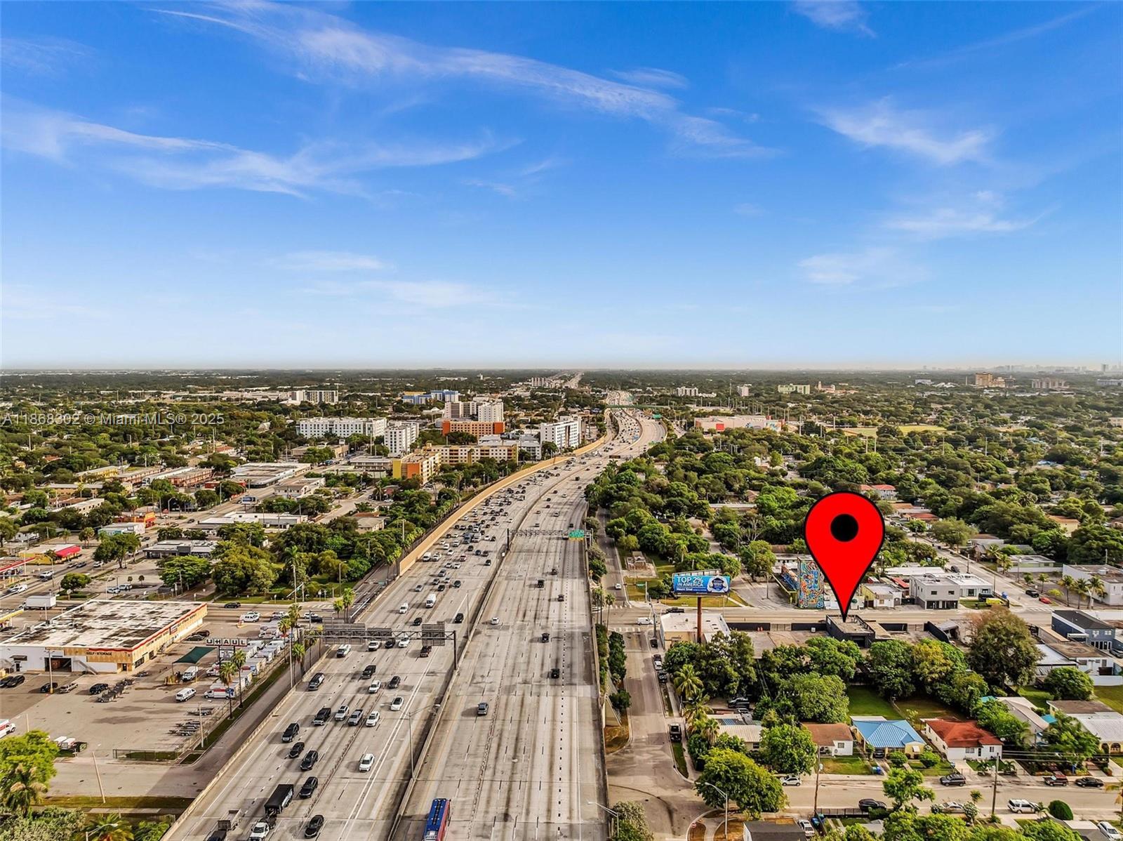 An aerial view shows a highway running through a city with a red location pin — 570 NW 54th St, Miami FL 33127, MIAMI, FL