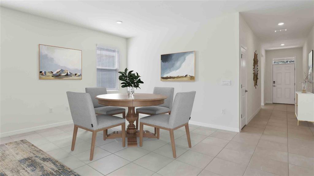 A dining area features a round wooden table, four gray chairs, and tile flooring — 8171 IVES PLACE, WILDWOOD, FL