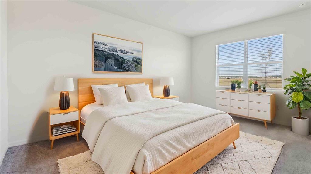 A bedroom features a wooden bed frame, white bedding, two nightstands, and a white dresser — 8171 IVES PLACE, WILDWOOD, FL