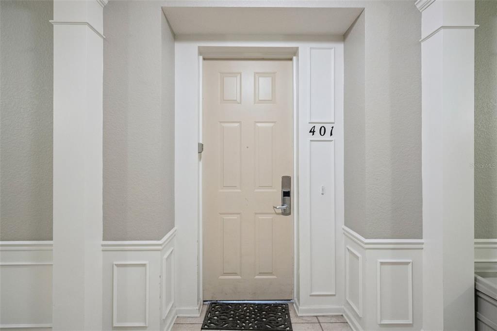 A beige apartment door labeled 401 is framed by white wainscoting and pillars — 4816 CAYVIEW AVENUE UNIT 40111, ORLANDO, FL