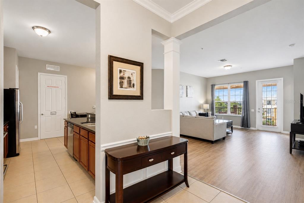 A view from a tiled entryway looking into a kitchen and a living room area — 4816 CAYVIEW AVENUE UNIT 40111, ORLANDO, FL