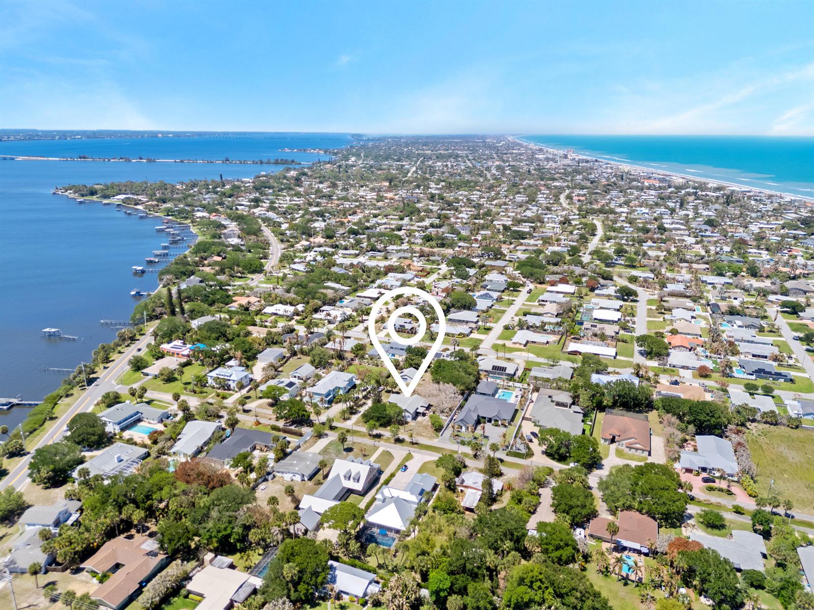An aerial view shows a residential neighborhood situated between a bay and the ocean — 532 Sunset Boulevard, Melbourne Beach FL 32951, MELBOURNE BEACH, FL