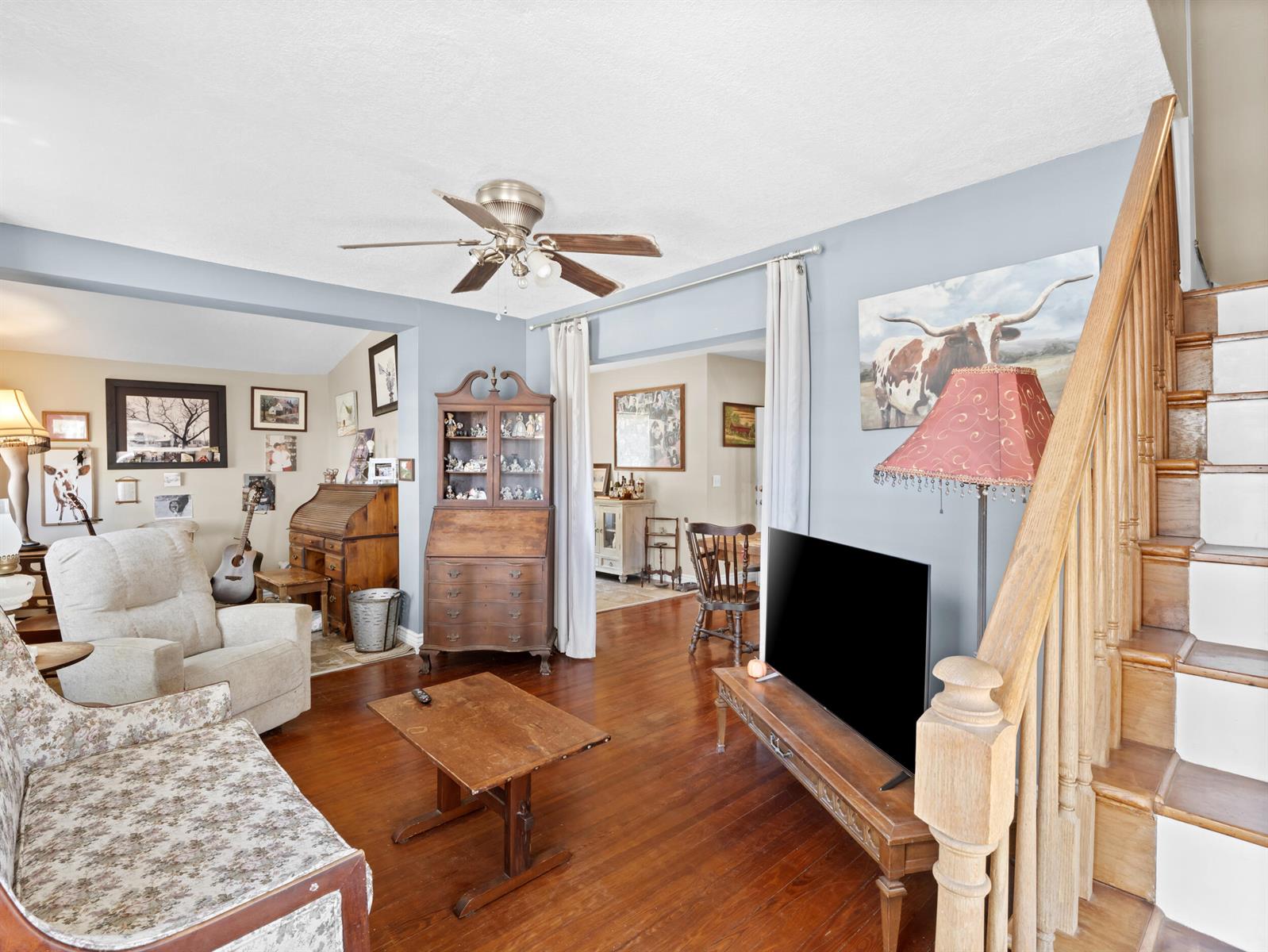 A living room features hardwood floors, a staircase, a television, and vintage-style furniture — 532 Sunset Boulevard, Melbourne Beach FL 32951, MELBOURNE BEACH, FL