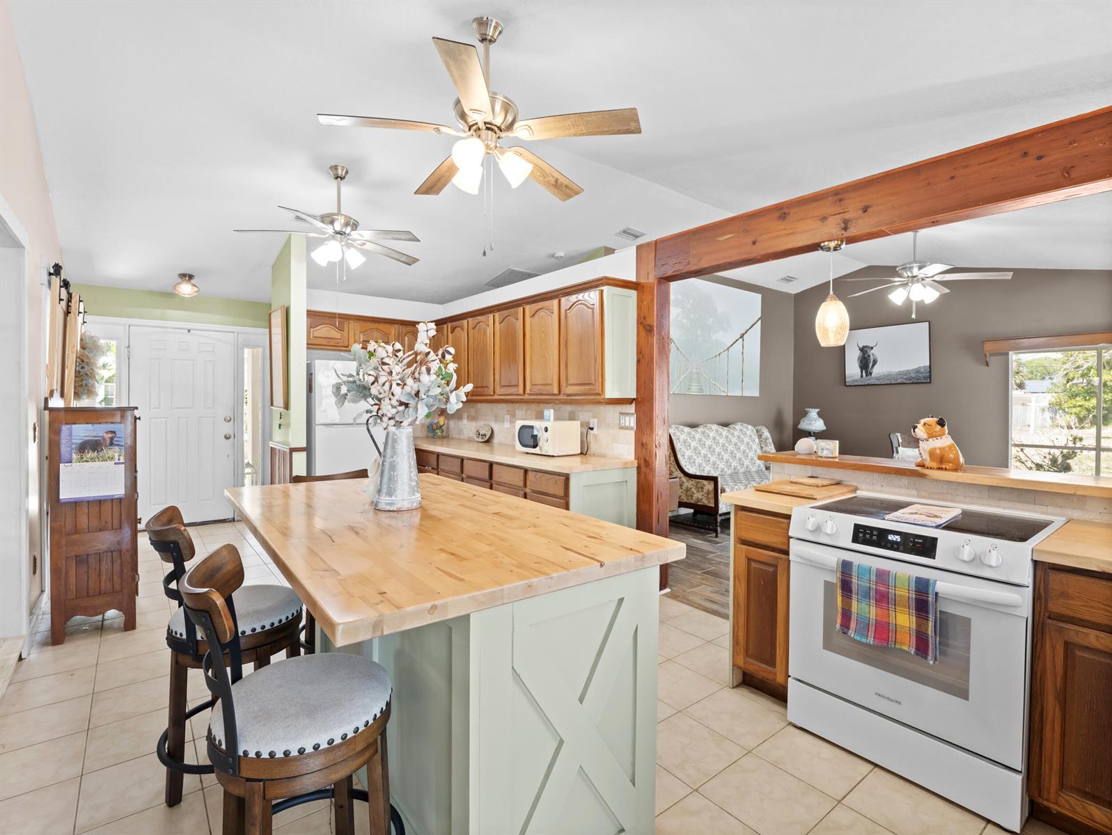A kitchen features a light green island with a wooden countertop and a white stove — 532 Sunset Boulevard, Melbourne Beach FL 32951, MELBOURNE BEACH, FL