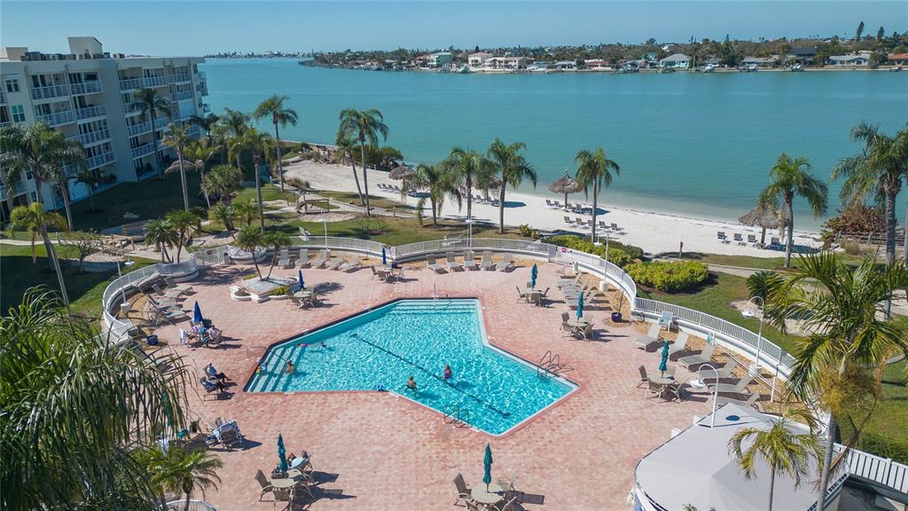 An aerial view of a swimming pool and patio area overlooking a beach and bay — 6080 BAHIA DEL MAR CIRCLE UNIT 113, ST PETERSBURG, FL