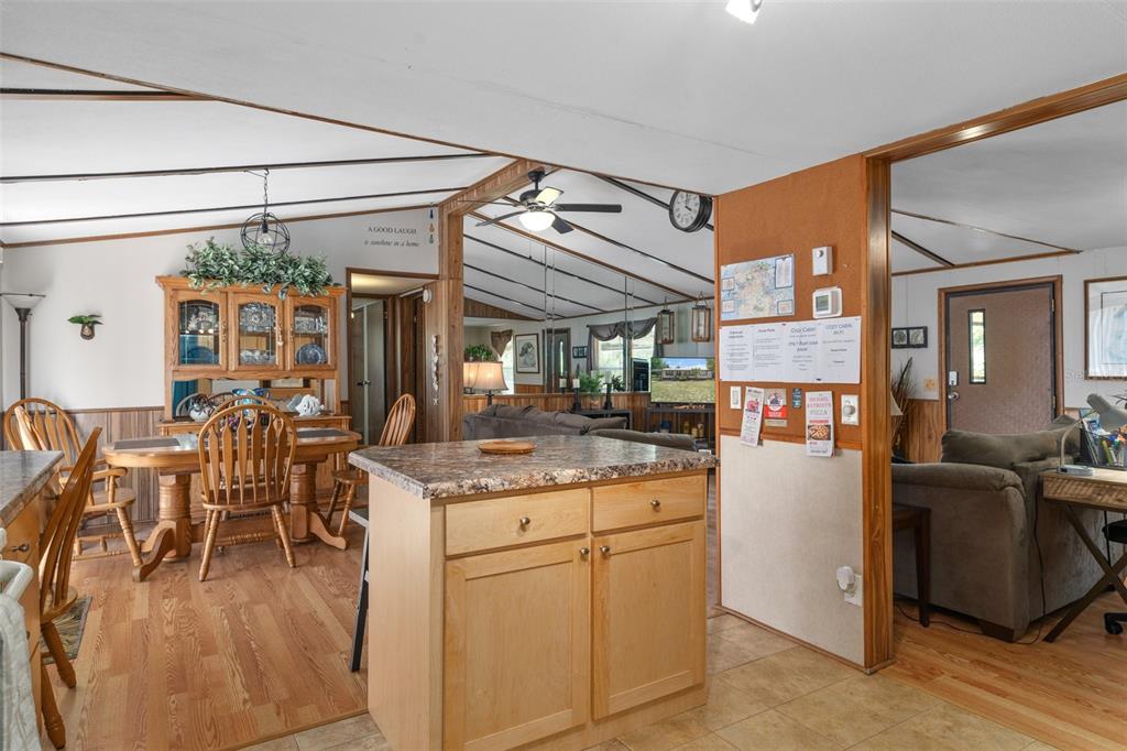 A kitchen island sits in the foreground of an open-concept living and dining area — 7510 W OTTER STREET, HOMOSASSA, FL