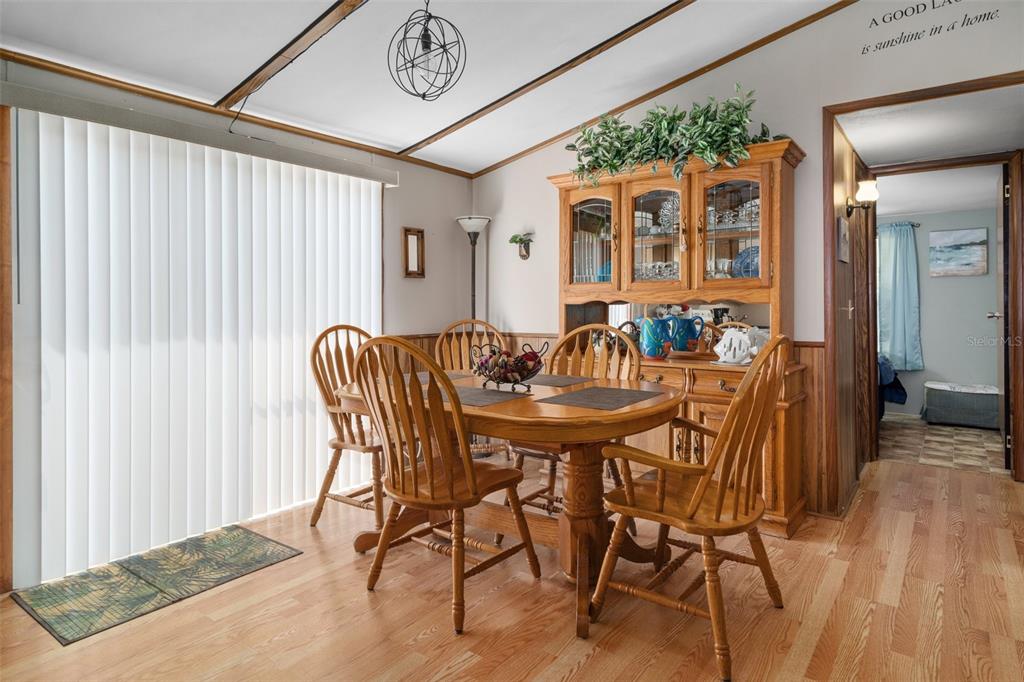 A dining room features a wooden table and chairs, a hutch, and vertical window blinds — 7510 W OTTER STREET, HOMOSASSA, FL