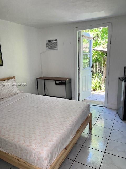 A bedroom features a bed, a desk, a wall-mounted air conditioner, and a glass door — 410 NW 31st St # 2, Miami FL 33127, MIAMI, FL