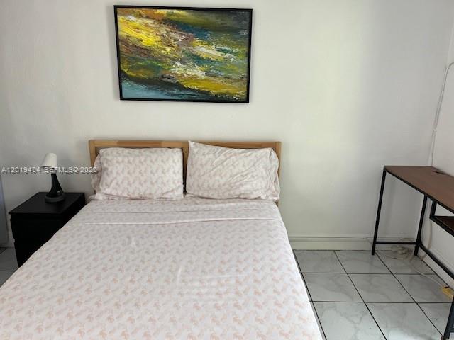 A bedroom features a bed with patterned linens, a nightstand, and a desk — 410 NW 31st St # 2, Miami FL 33127, MIAMI, FL