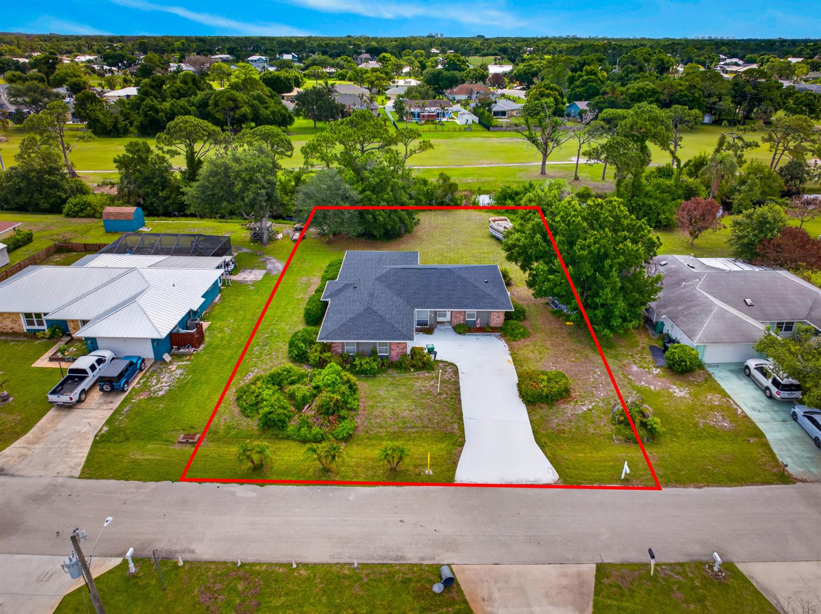 An aerial view shows a single-story house with a dark roof and a concrete driveway — 5110 Eagle Drive, Fort Pierce FL 34951, FORT PIERCE, FL