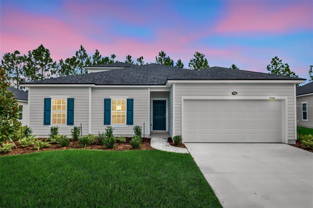 A single-story house with light gray siding, a two-car garage, and blue shutters — 3766 HOLSTEIN WAY, GREEN COVE SPRINGS, FL