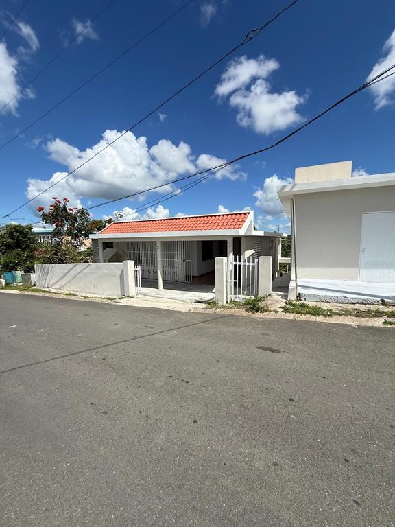 A single-story house with a red tiled roof and a white gated front porch — PR 156 Quebrada Grande QUEBRADA GRANDE, BARRANQUITAS, PR