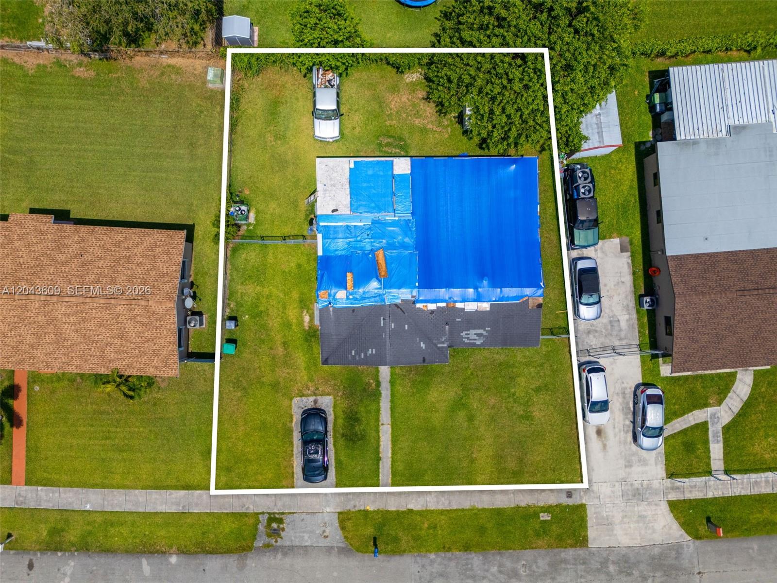 An aerial view shows a house with a blue tarp covering part of its roof — 14125 SW 109th Pl, Miami FL 33176, MIAMI, FL