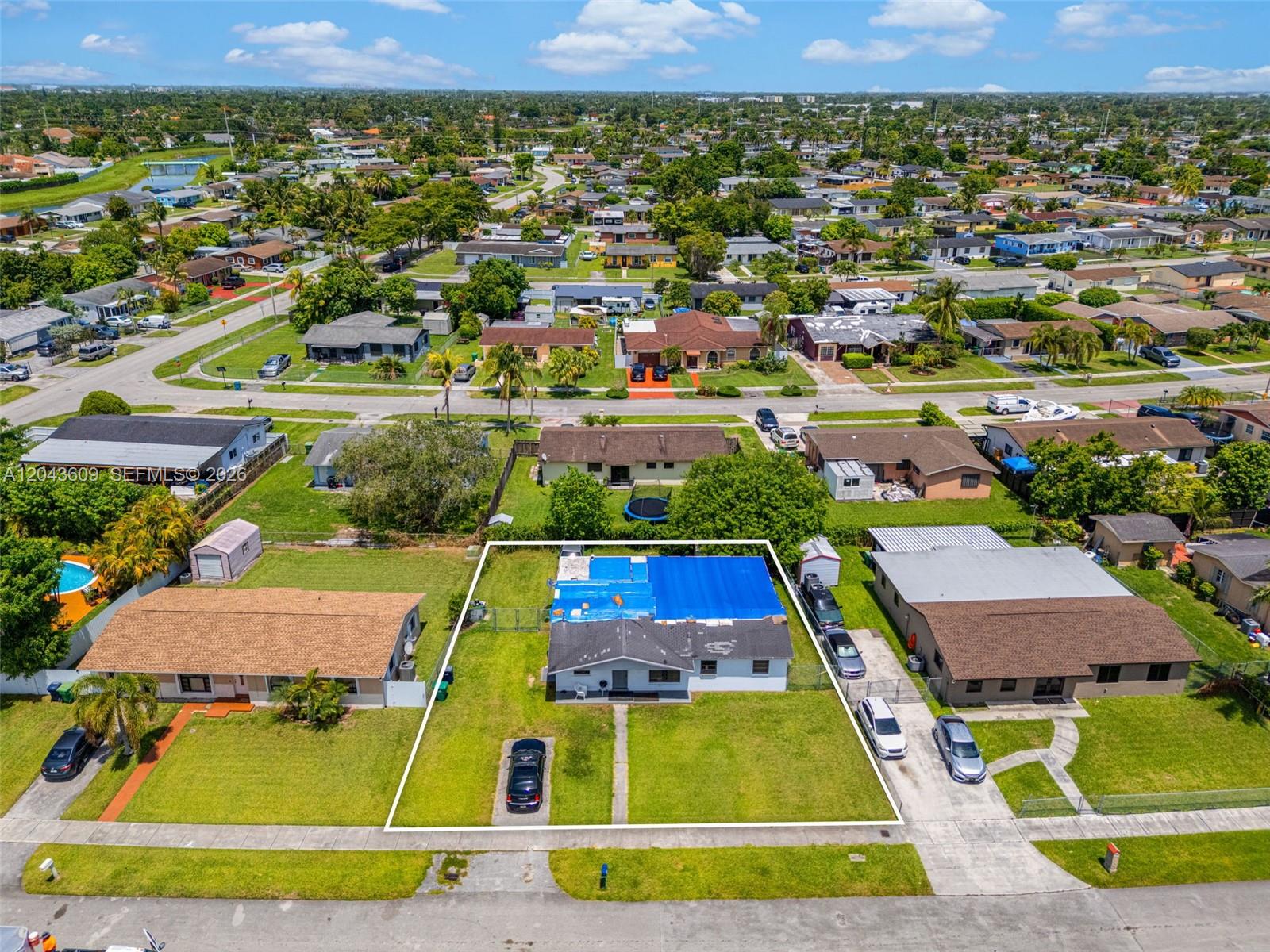 An aerial view shows a single-story house with a blue tarp covering its roof — 14125 SW 109th Pl, Miami FL 33176, MIAMI, FL