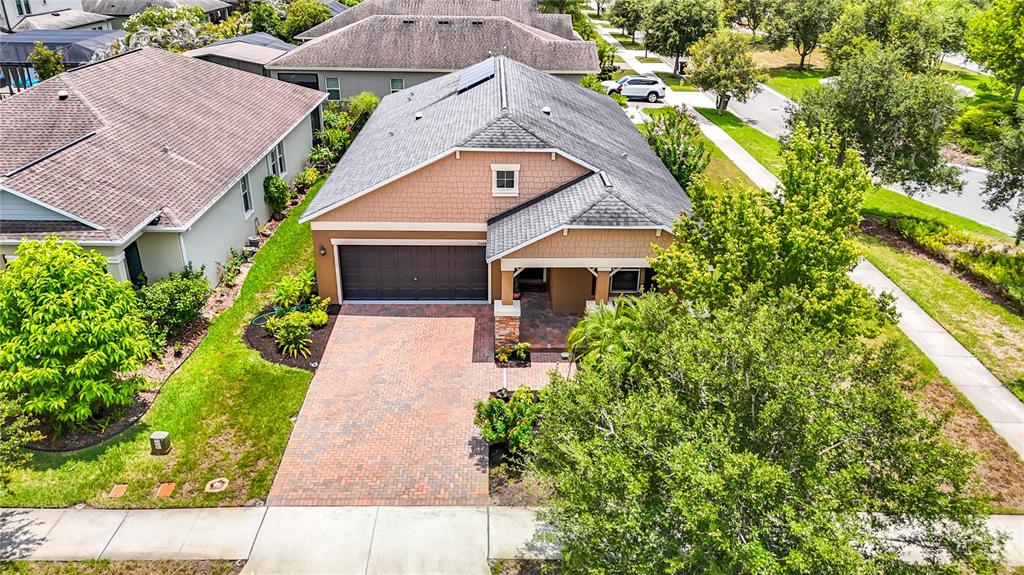 An aerial view shows a single-story house with a brick driveway and a shingled roof — 17488 TERRAZZO WAY, LAND O LAKES, FL