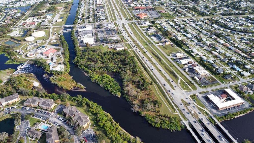 An aerial view shows a river, a multi-lane road, commercial buildings, and residential neighborhoods — 14161 S TAMIAMI TRAIL, NORTH PORT, FL