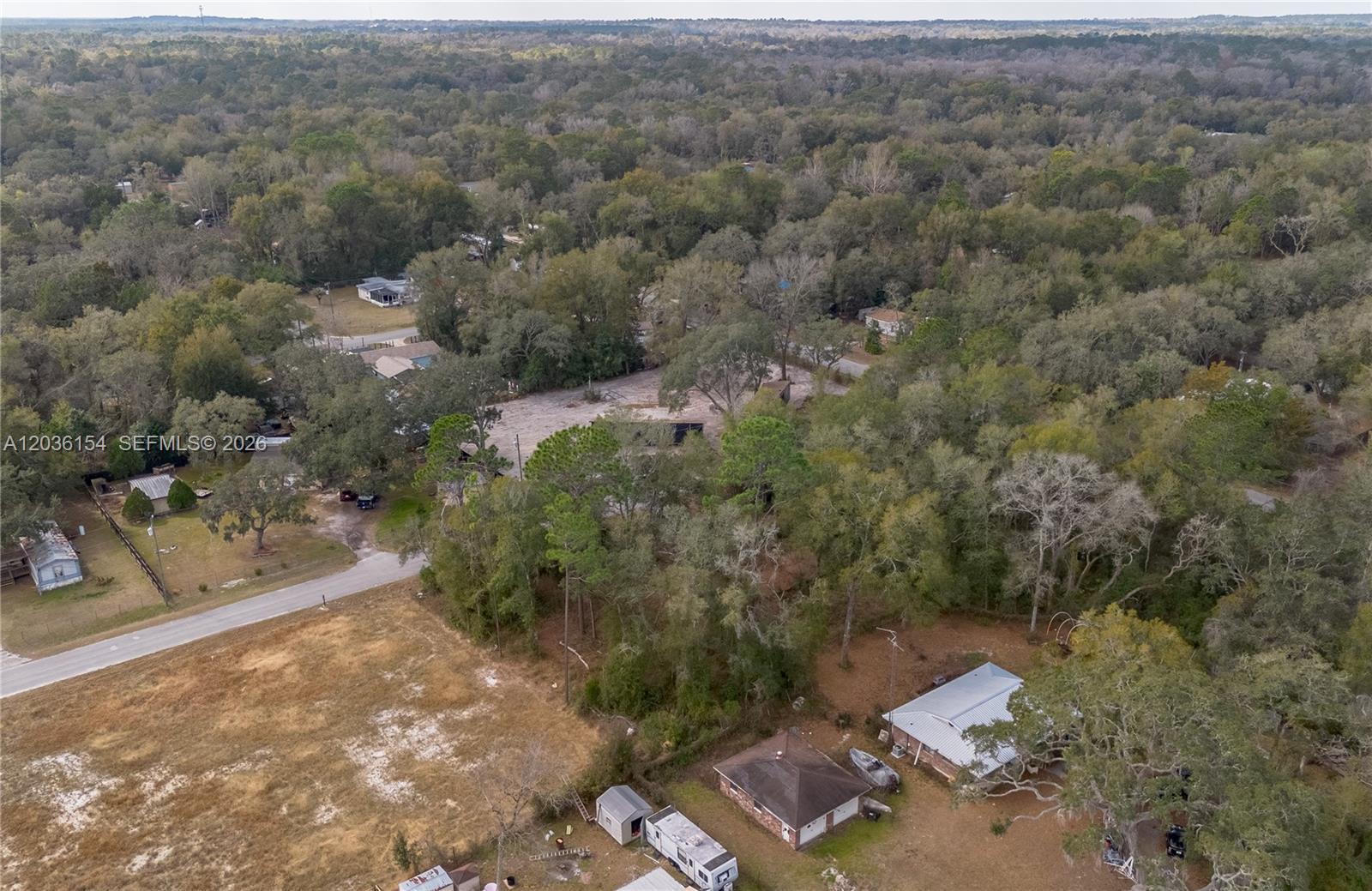 An aerial view shows a rural residential area with scattered houses, trees, and dirt roads — NW 13th ST, Ocala FL 34482, OCALA, FL