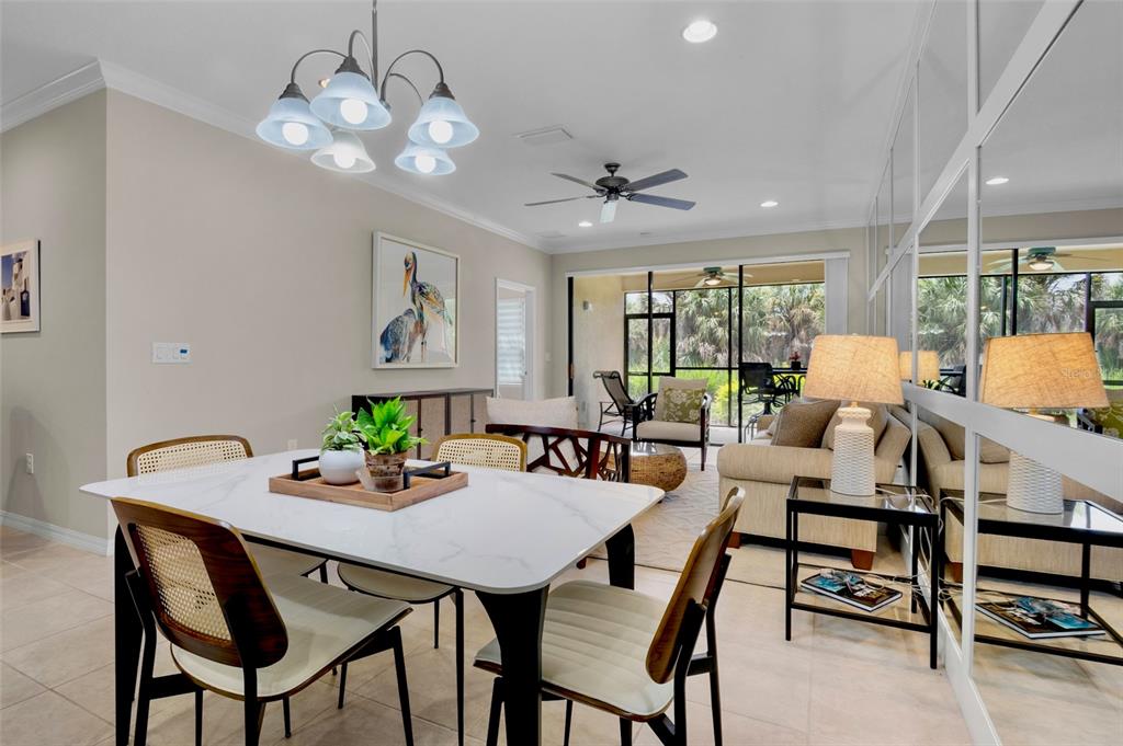 A dining area with a marble-topped table opens into a living room with mirrored walls — 5425 CICERONE STREET UNIT 103, SARASOTA, FL