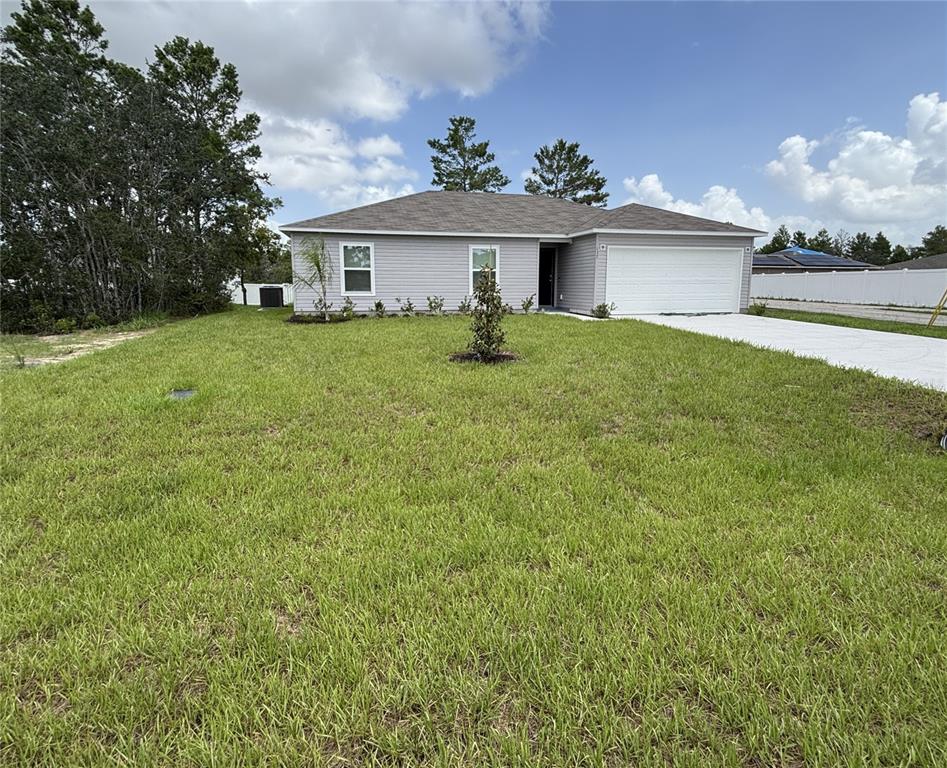 A single-story gray house with a white garage door sits on a grassy lot — 137 MAPLE DRIVE W, KISSIMMEE, FL