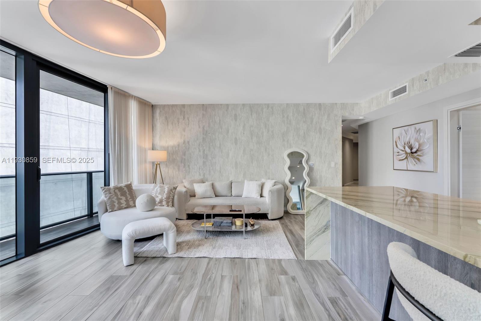 A modern living room features a sofa, circular chair, coffee table, and light wood flooring — 801 S Miami Ave # 1805, Miami FL 33130, MIAMI, FL