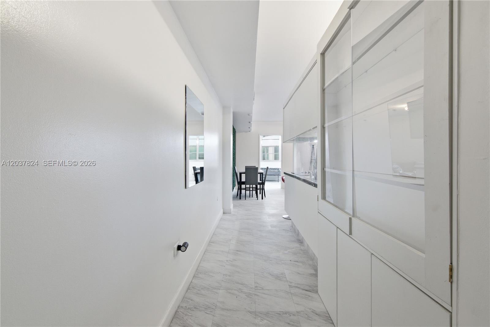 A white hallway with marble-look tile flooring leads to a dining area — 801 Brickell Bay Dr # 764, Miami FL 33131, MIAMI, FL