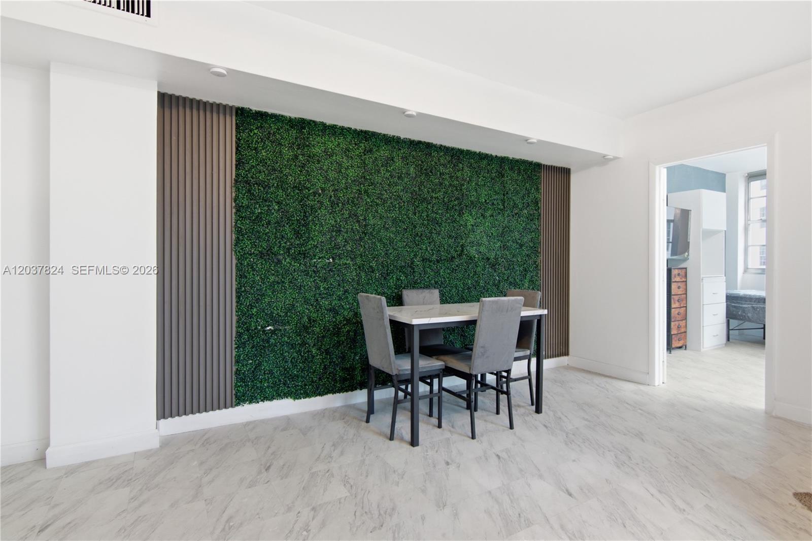 A dining area features a green wall accent with vertical slats and a marble-topped table — 801 Brickell Bay Dr # 764, Miami FL 33131, MIAMI, FL