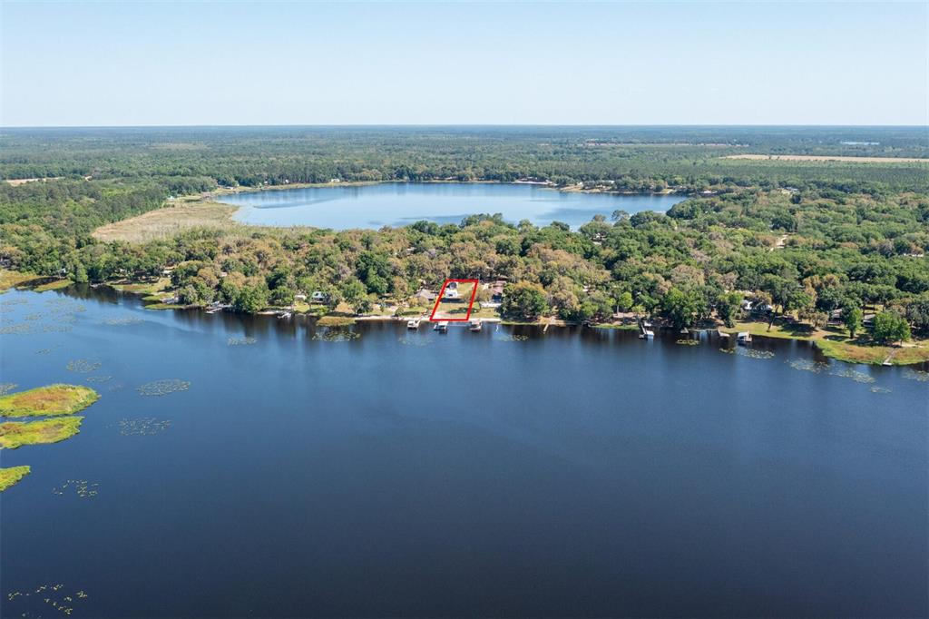 An aerial view shows a waterfront property outlined in red on a large lake — 120 LITTLE ORANGE LAKE DRIVE, HAWTHORNE, FL