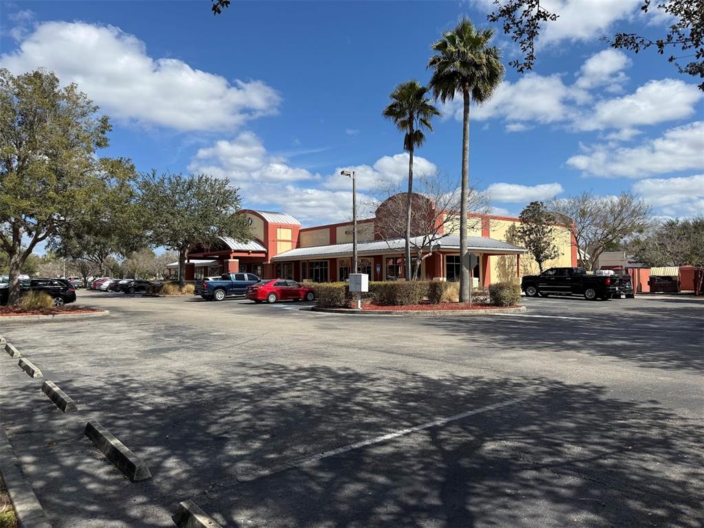 A commercial building with a parking lot and two tall palm trees under a blue sky — 2611 SW 19TH AVENUE ROAD UNIT 700, OCALA, FL
