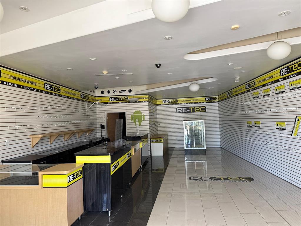 A commercial retail space features slat-wall displays, a service counter, and tiled flooring — 2611 SW 19TH AVENUE ROAD UNIT 700, OCALA, FL