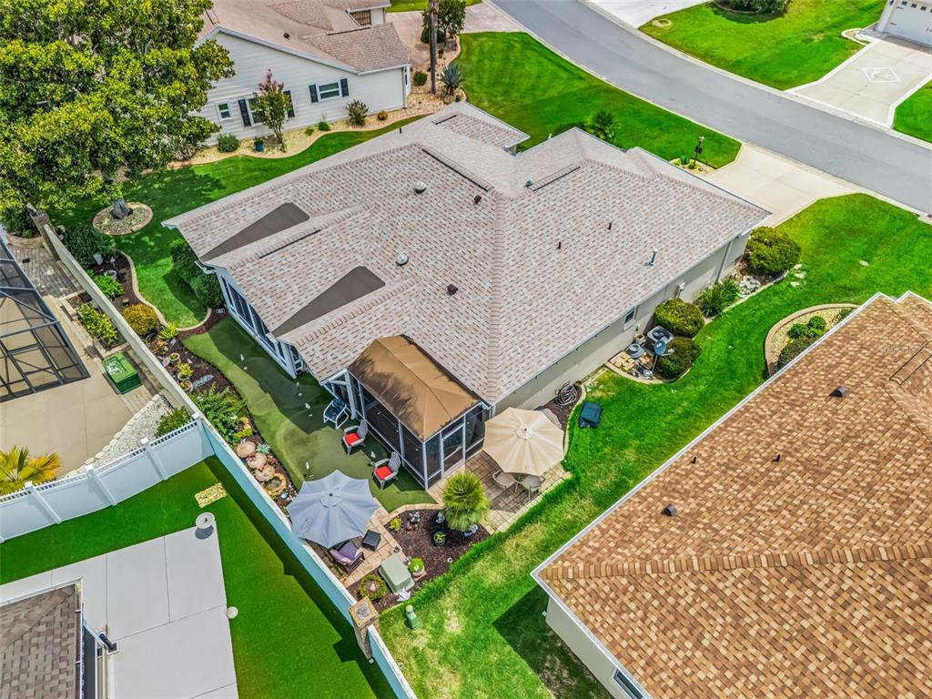 An aerial view shows a house with a shingled roof, screened patio, and backyard landscaping — 17770 SE 85TH ELLERBE AVENUE, THE VILLAGES, FL