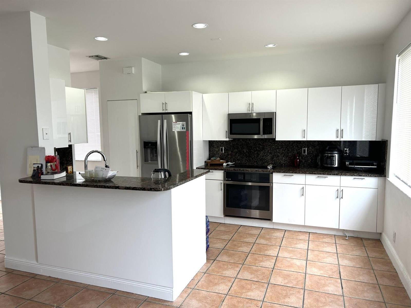 A kitchen with white cabinets, stainless steel appliances, dark granite countertops, and tiled flooring — 4361 Dogwood Circle, Weston FL 33331, WESTON, FL