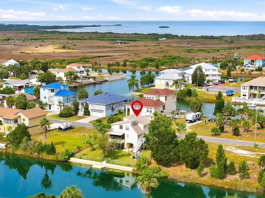 A floating dock sits on a calm canal in front of several waterfront houses — 3294 GARDENIA DRIVE, HERNANDO BEACH, FL