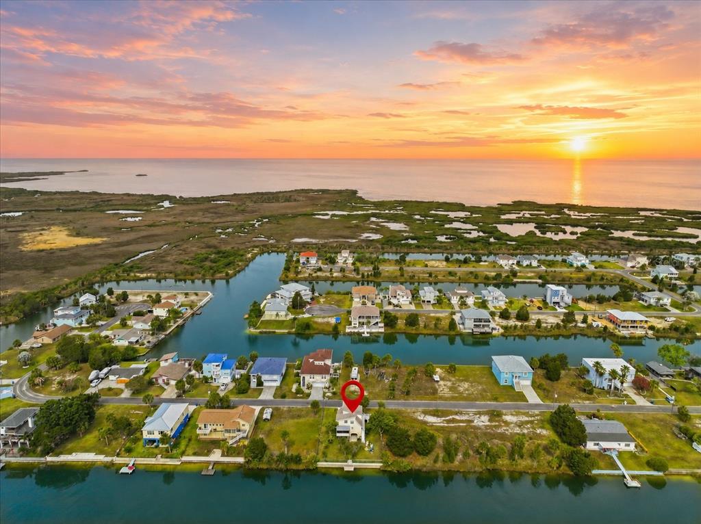 An aerial view shows a waterfront house with a red pin in a coastal neighborhood — 3294 GARDENIA DRIVE, HERNANDO BEACH, FL