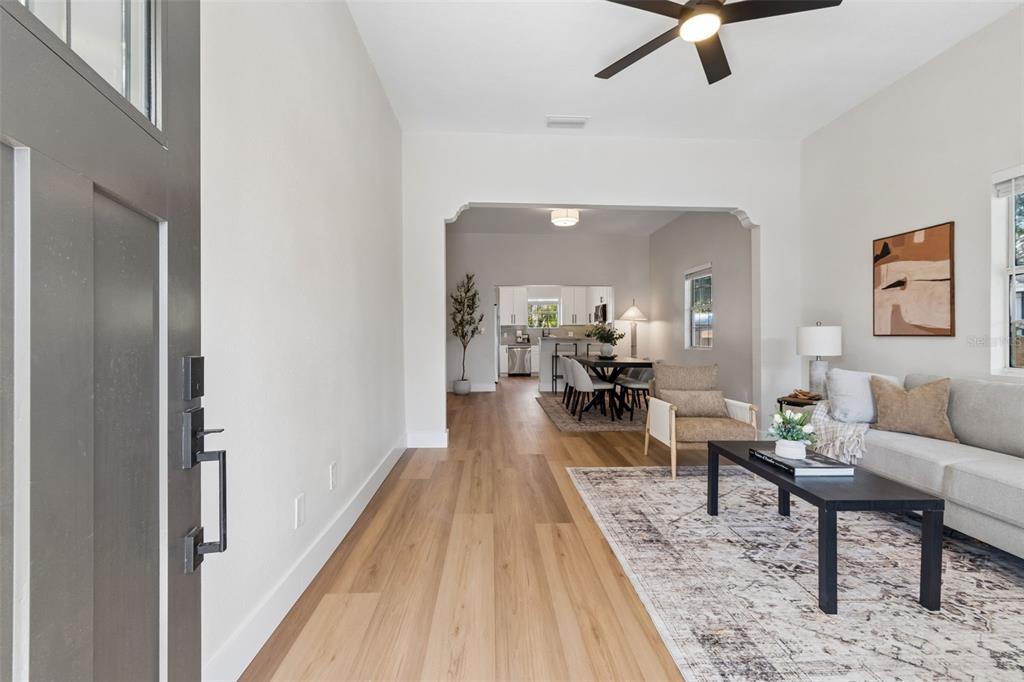 An entryway leads into a living room with light wood floors and an open kitchen — 3022 SANCHEZ STREET, TAMPA, FL
