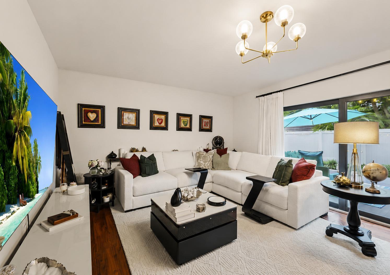 A living room features a white sectional sofa, a black coffee table, and a large television — 7707 77th Way # 7707, West Palm Beach FL 33407, WEST PALM BEACH, FL