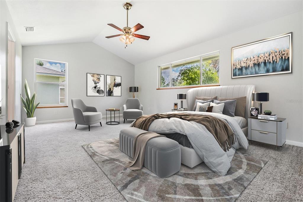 A bedroom features a vaulted ceiling, a bed with a bench, and two armchairs — 6536 NORTHLAKE DRIVE, ZEPHYRHILLS, FL