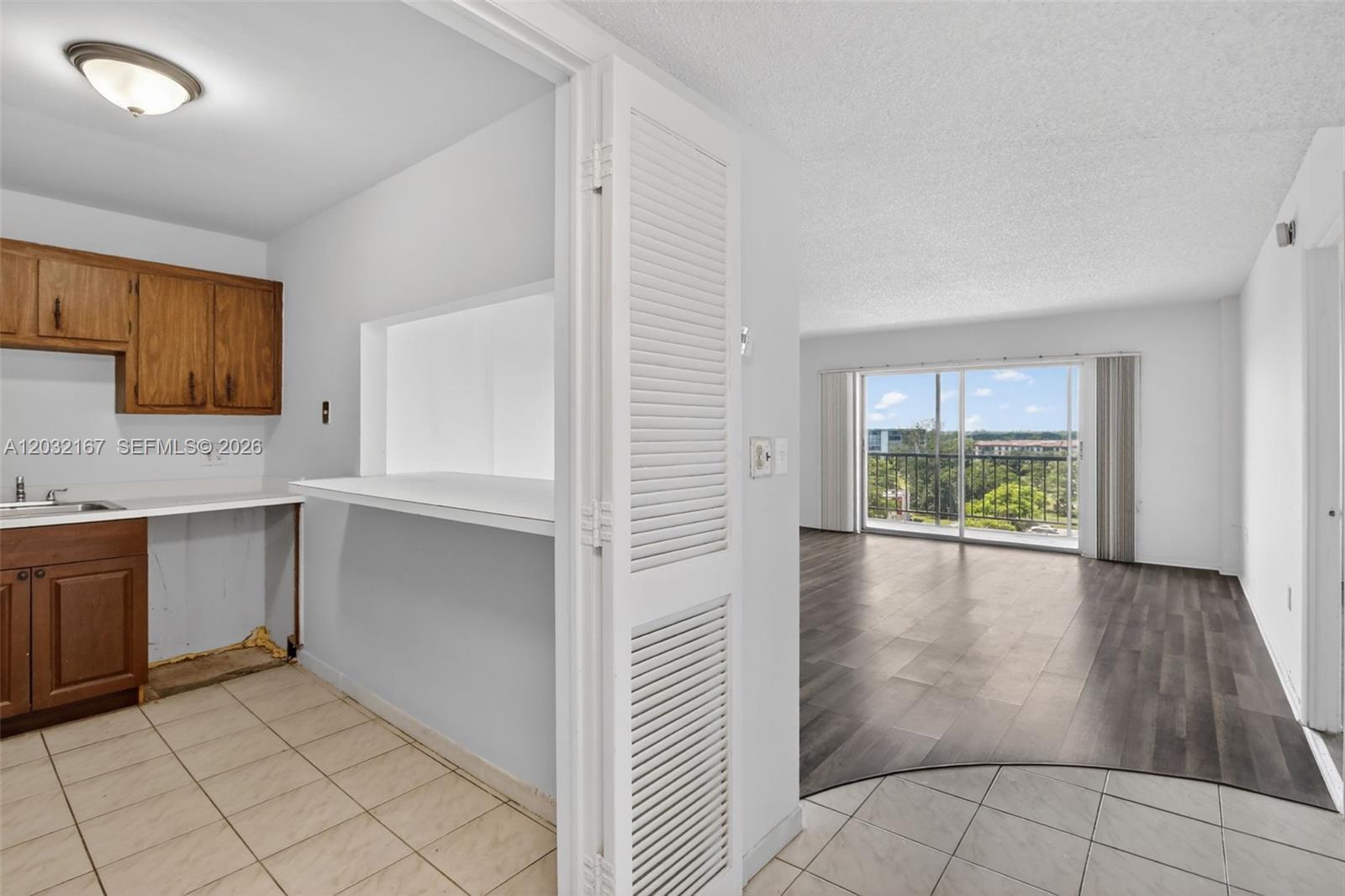 A view from a screened balcony overlooking a parking lot and apartment buildings — 4174 Inverrary Dr # 805, Lauderhill FL 33319, LAUDERHILL, FL