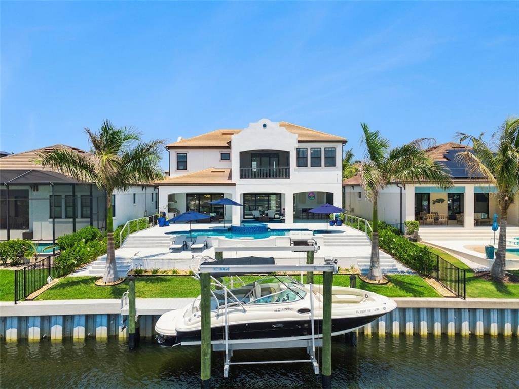 A white two-story house with a pool, patio, and boat lift on a canal — 3028 CHRISTOPHERS WATCH LANE, RUSKIN, FL