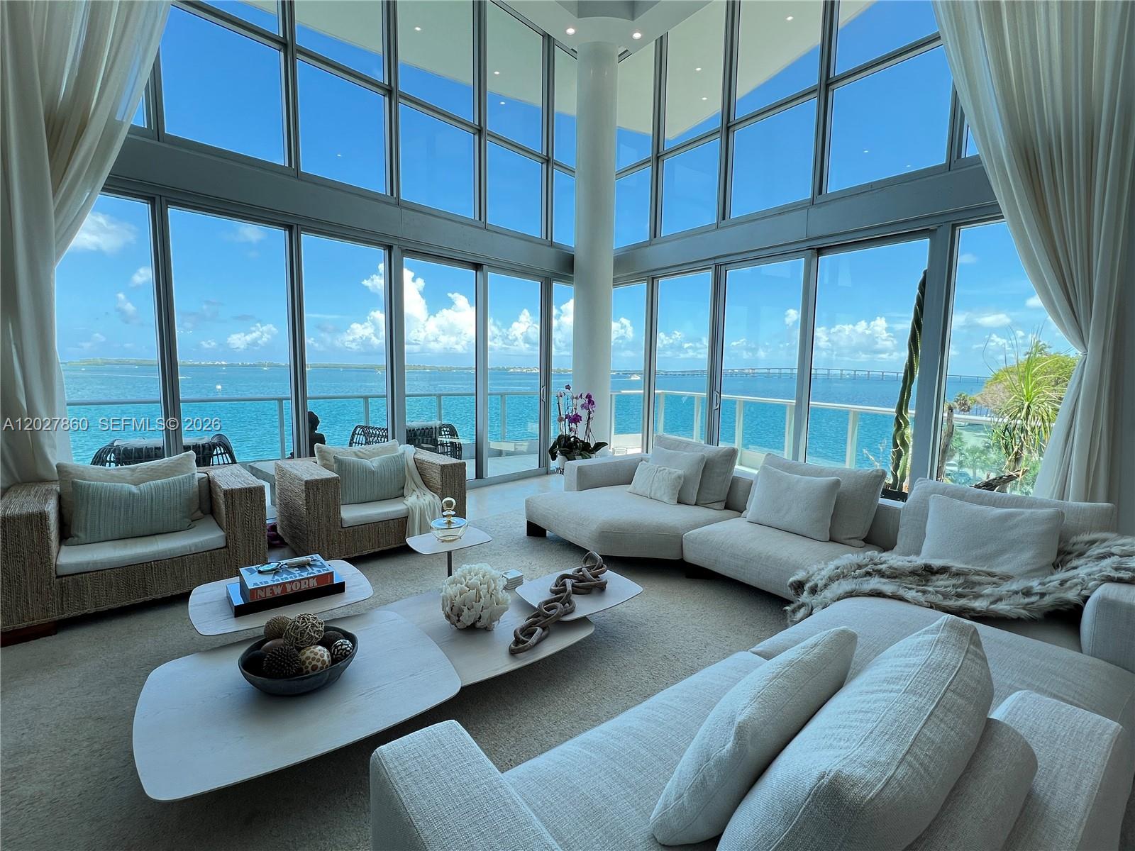 A spacious living room features floor-to-ceiling windows with expansive ocean views and modern furniture — 1331 Brickell Bay Dr # 48, Miami FL 33131, MIAMI, FL