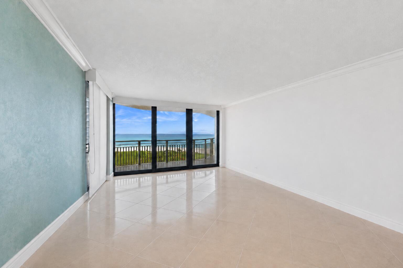 An empty room with light tile flooring, a blue accent wall, and floor-to-ceiling ocean views — 3000 N Ocean Drive # A, Singer Island FL 33404, SINGER ISLAND, FL