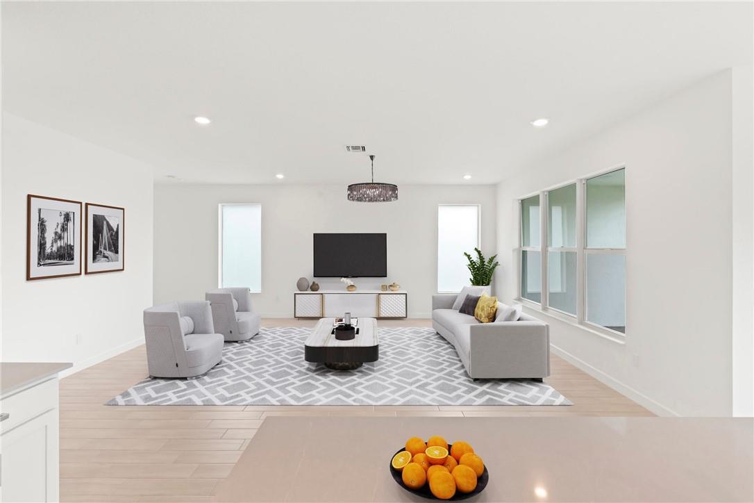 A modern living room features a grey area rug, light wood floors, and white walls — 22974 Hillshire Road, Boca Raton FL 33433, BOCA RATON, FL