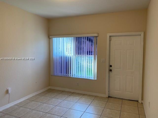 A two-story house with a brown garage, a balcony, and a paved driveway — 646 SW 7th Ter, Florida City FL 33034, FLORIDA CITY, FL