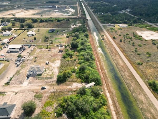 An aerial view shows a rural property with a canal, dirt roads, and scattered buildings — 7969 13TH TER, La Belle FL 33935, LA BELLE, FL