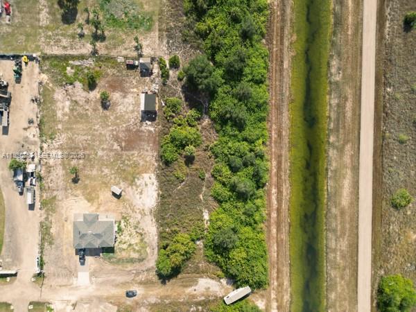An aerial view shows a residential lot with a house, outbuildings, vegetation, and a canal — 7969 13TH TER, La Belle FL 33935, LA BELLE, FL