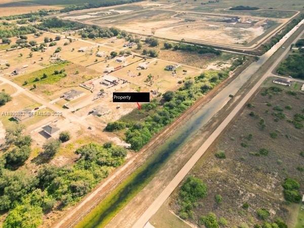 This aerial view shows a vacant lot marked as property next to a canal — 7969 13TH TER, La Belle FL 33935, LA BELLE, FL