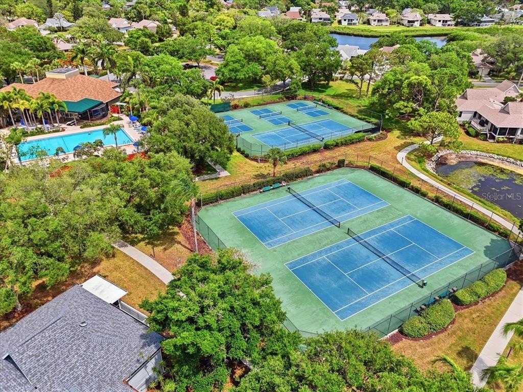 An aerial view shows two tennis courts, a swimming pool, and a clubhouse — 992 SPINNAKER COURT, TARPON SPRINGS, FL