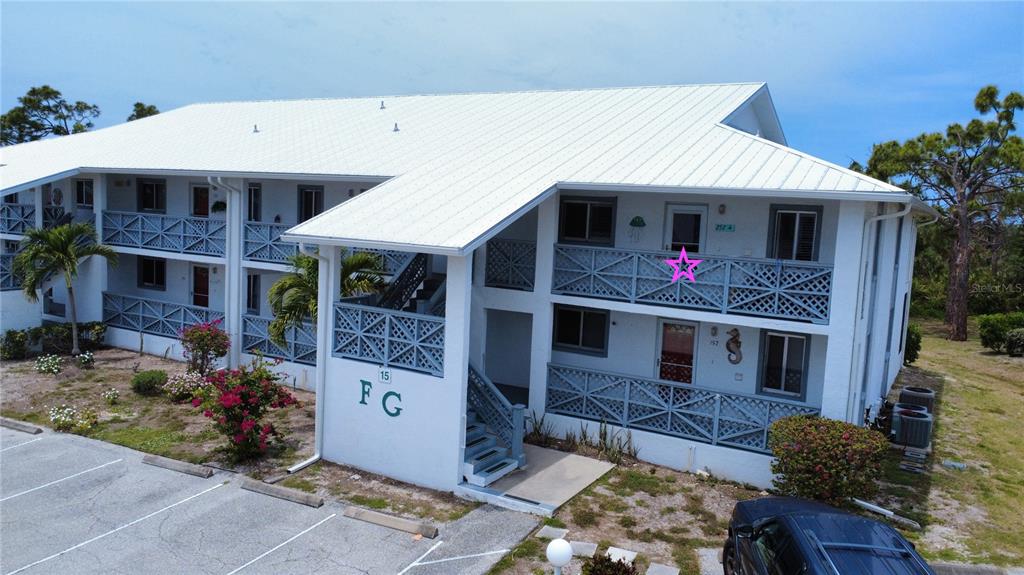 An exterior view of a two-story white apartment building with a star marking a unit — 6800 PLACIDA ROAD UNIT 257, ENGLEWOOD, FL