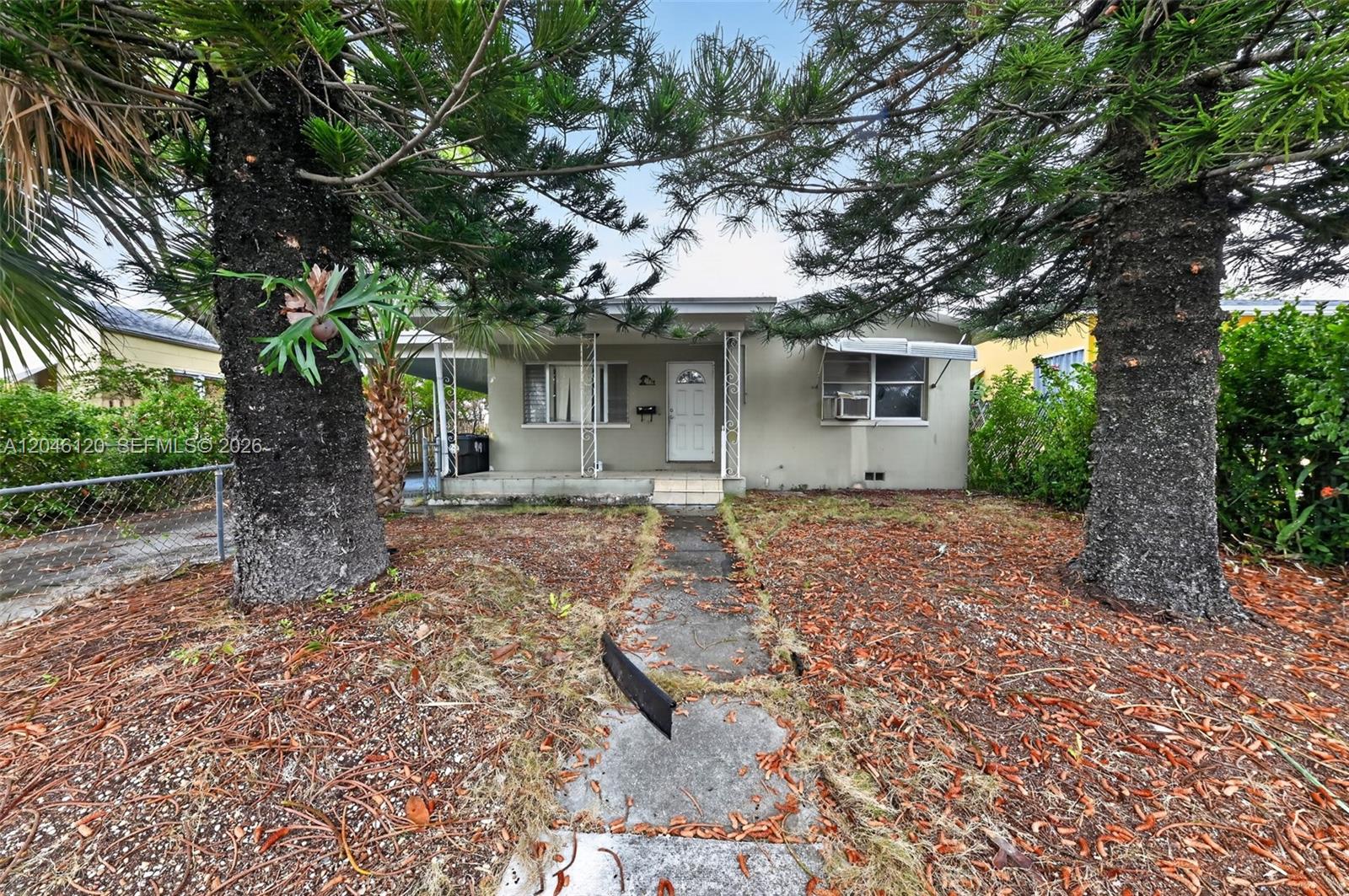 A single-story house with a concrete walkway, two large trees, and a covered front porch — 914 N K St, Lake Worth FL 33460, LAKE WORTH, FL